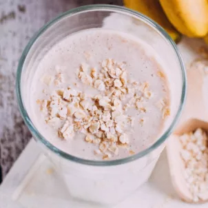 Homemade glass of oat milk next to honeycomb