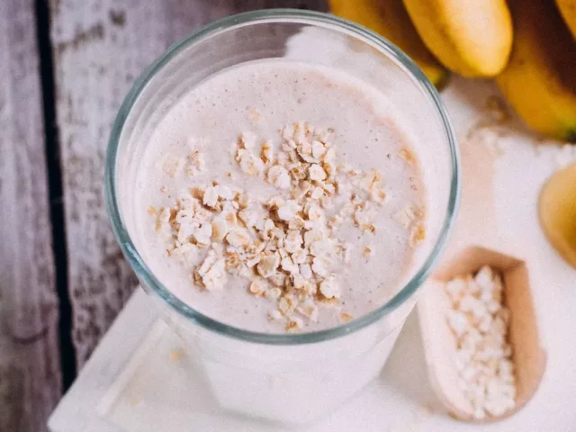 Homemade glass of oat milk next to honeycomb