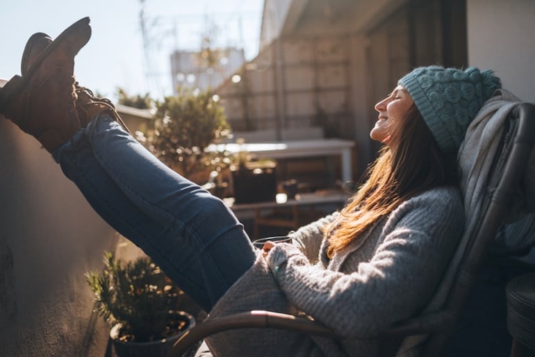 Relaxed, calm woman on her porch enjoying a stress-free day thanks to the health benefits of ashwagandha