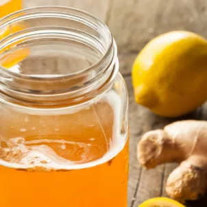 Mason jar of fresh kombucha with ginger and lemon