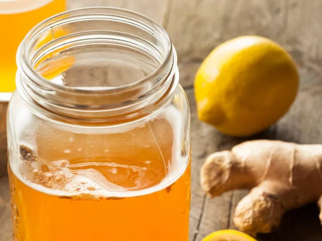 Mason jar of fresh kombucha with ginger and lemon