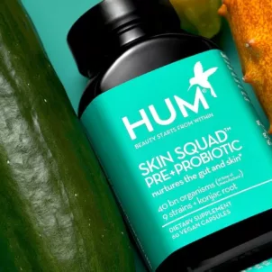 HUM Skin Squad Probiotic supplement for clear skin lined up next to cucumber and other nutritious foods