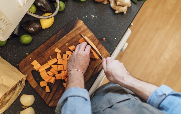 Man prepping sweet potato fries as part of a Trader Joe's meal plan