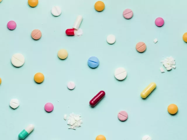 Colorful vitamins laid out on bright blue background