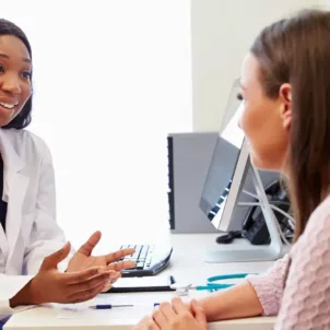 Registered dietitian sitting at desk speaking to a patient