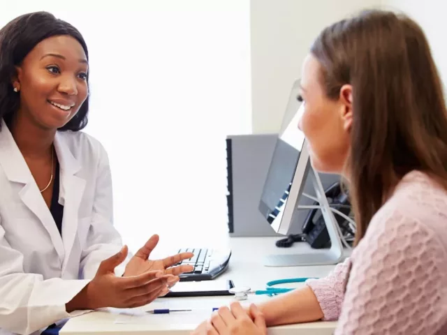 Registered dietitian sitting at desk speaking to a patient