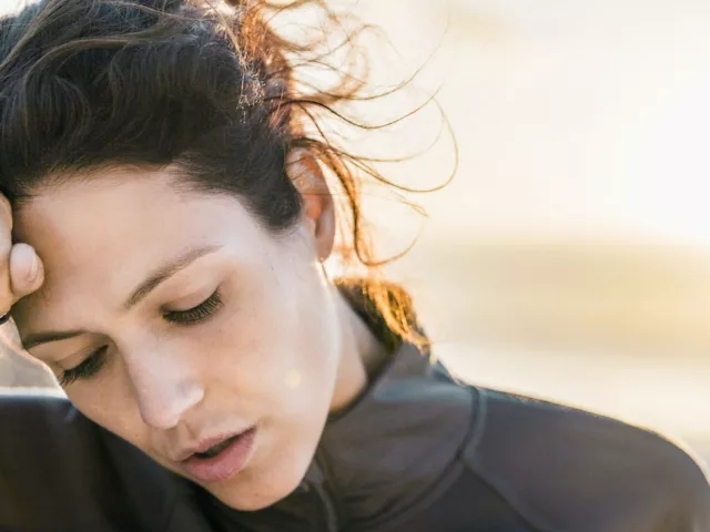 Woman outdoors with fist to face suffering from iron deficiency