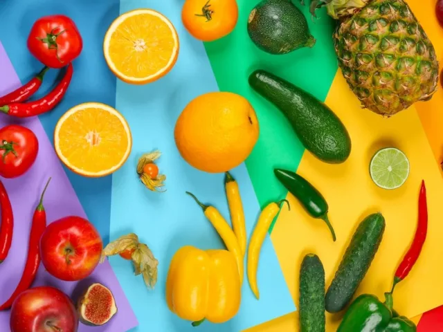 Variety of colorful fruits and vegetables that will let you "eat the rainbow" on rainbow background