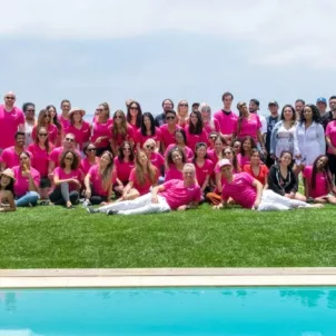 Group photo of HUM Nutrition team in pink shirts in front of pool in Malibu