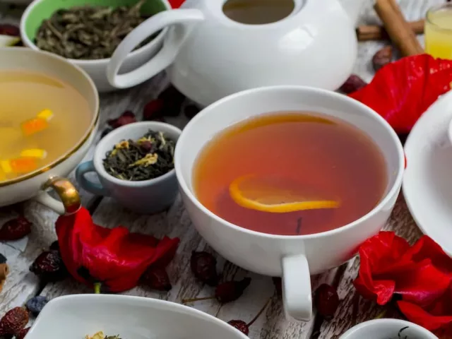 Assortment of teas on a white wooden table covered with flowers