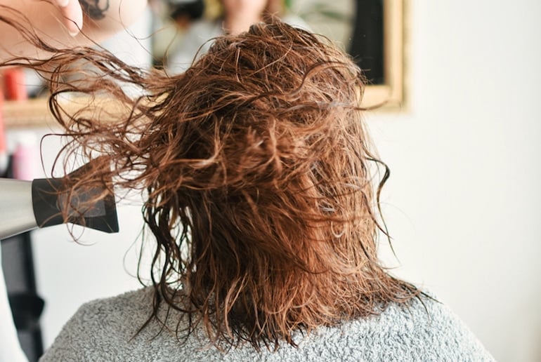 Redheaded woman getting her hair blown out