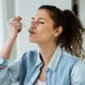 Woman eating spoonful of healthy snacks with glee
