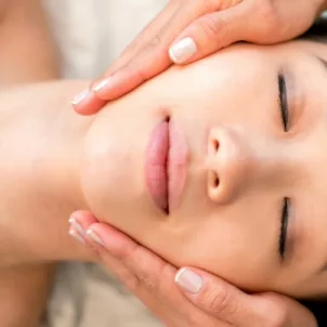 Overhead shot of woman with beautiful skin after microinfusion macial with esthetician holding her face