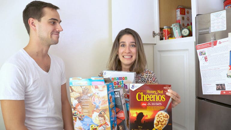 A registered dietitian tries to hold several boxes of sugary breakfast cereal from the pantry of a client.