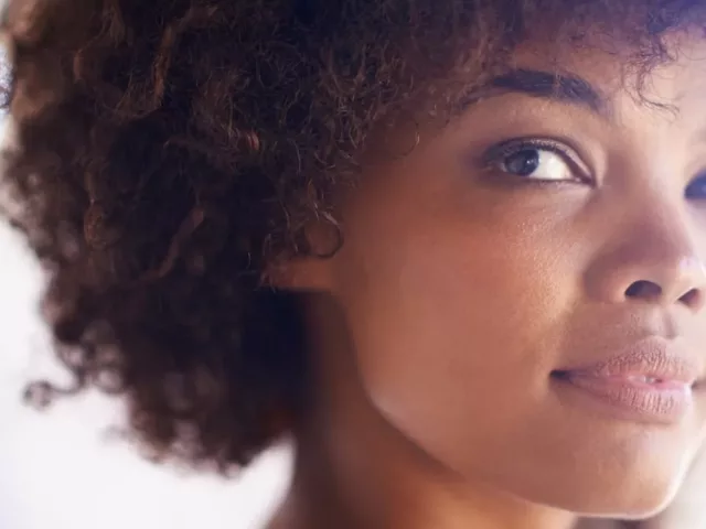 Young woman with natural hair and clean skin free from hyperpigmentation