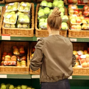 Woman looking at apples at grocery store