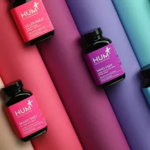 HUM Nutrition supplement bottles on rainbow spectrum