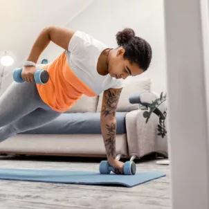 Woman doing a full body workout at home with dumbbells