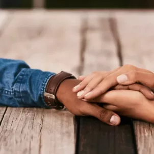 Couple holding hands on wooden table