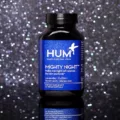 Bottle of HUM Nutrition Mighty Night supplement for skin cell renewal amidst dark starry background