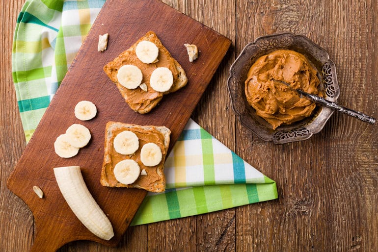 nut-butter toast with banana on wooden table