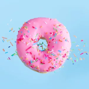 Pink donut floating over blue background