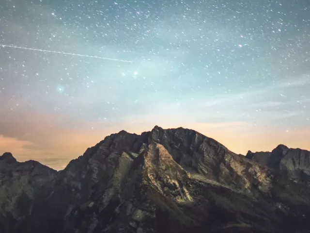 Blue and orange starry horizon atop a mountain