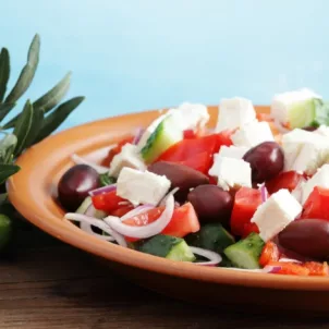 Greek salad on table with Mediterranean Sea in background