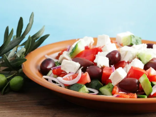 Greek salad on table with Mediterranean Sea in background