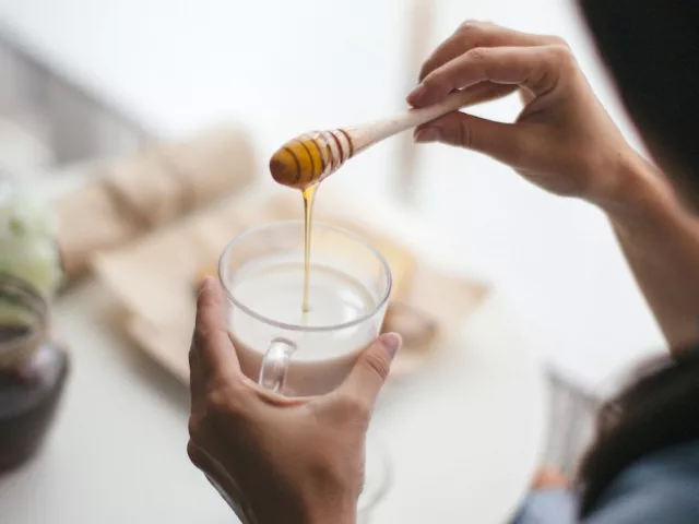 Woman using honey as the healthiest sweetener