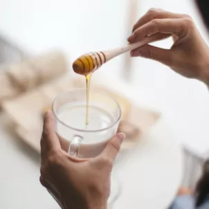 Woman using honey as the healthiest sweetener