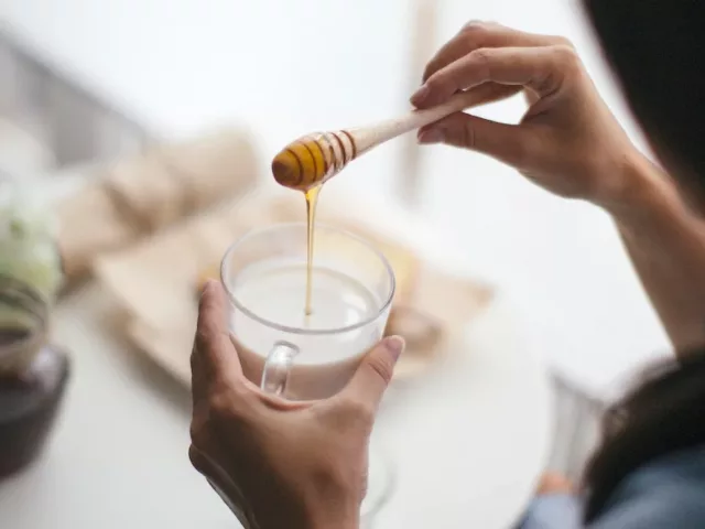 Woman using honey as the healthiest sweetener