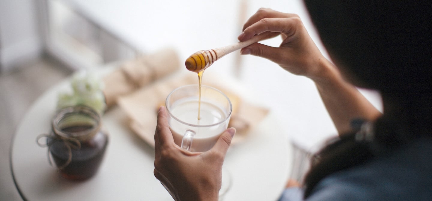 Woman using honey as the healthiest sweetener