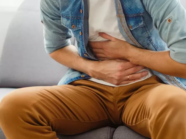 Man feeling leaky gut symptoms