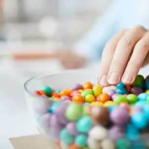 Woman's hand reaching for candy while working