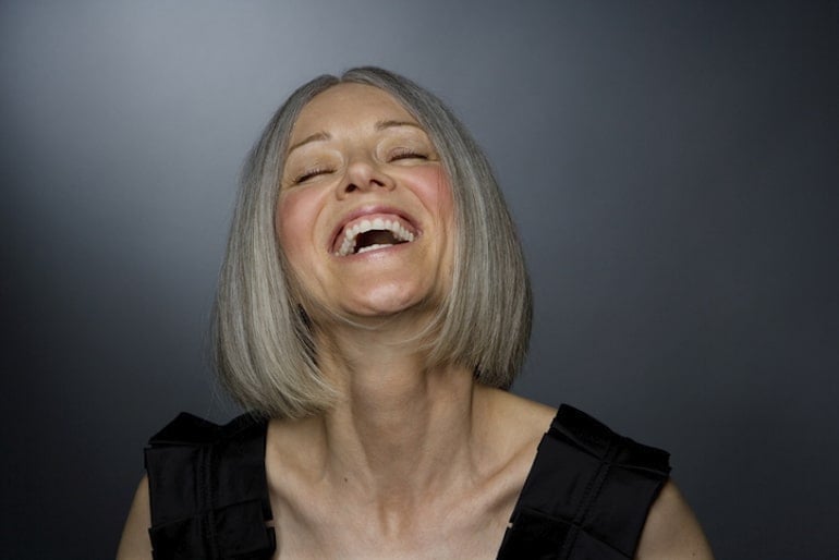 Mature woman laughing, with no wrinkles because she takes different types of collagen for plump skin