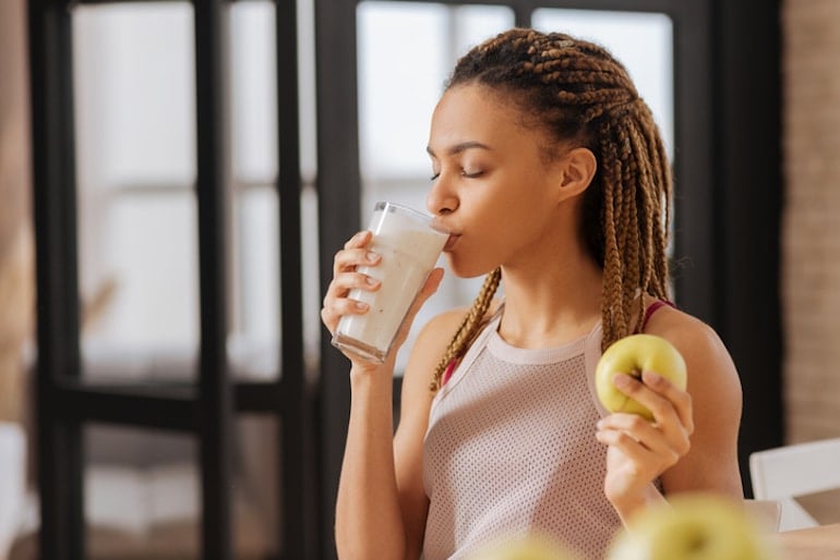 Woman drinking fortified milk to have more foods high in vitamin D