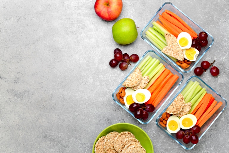 Meal prep with vegetables, fruit, crackers, and other complex carbohydrates to help build muscle