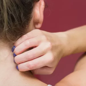 Back of woman scratching her neck