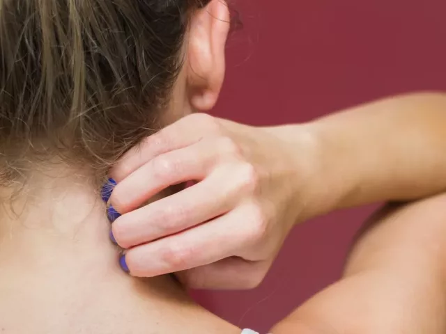 Back of woman scratching her neck