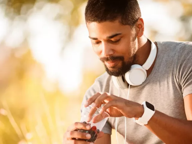 Man eating berries for carbohydrates, which will help him build muscle