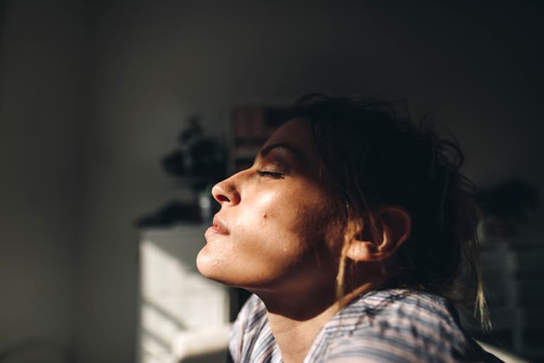 Woman's face half in the sun, half in shadow, to illustrate the importance of vitamin D aka the sunshine vitamin