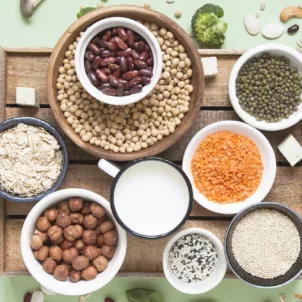 Table setting of healthy anti-candida diet foods including broccoli, gluten-free oats, anti-fungal garlic, and nuts