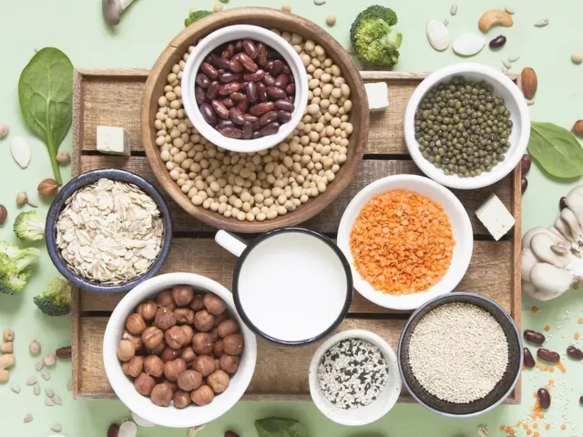 Table setting of healthy anti-candida diet foods including broccoli, gluten-free oats, anti-fungal garlic, and nuts