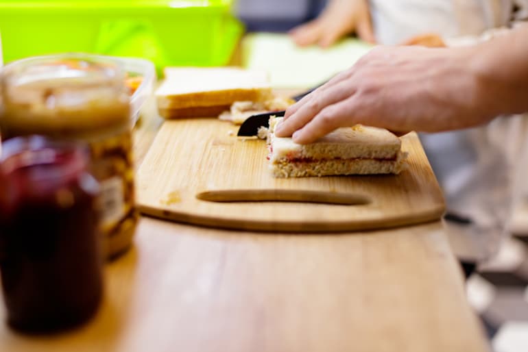 Man making a peanut butter and jelly sandwich to satisfy his craving for fatty foods