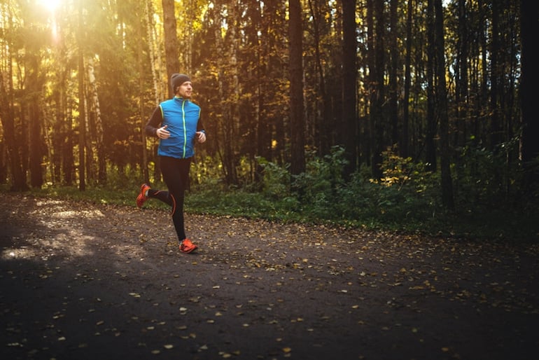 Man running in solitude at daybreak through the forest, who prizes fitness and the importance of alone time