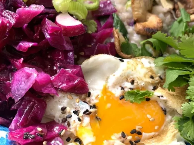 Custom easy congee recipe dish with mushrooms, green onion, cilantro, radishes, and egg