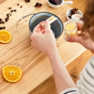 Woman making DIY beauty recipes with sugar, lemon, coffee, and other pantry staples