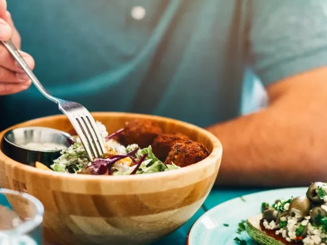 Man eating salad with healthy fats