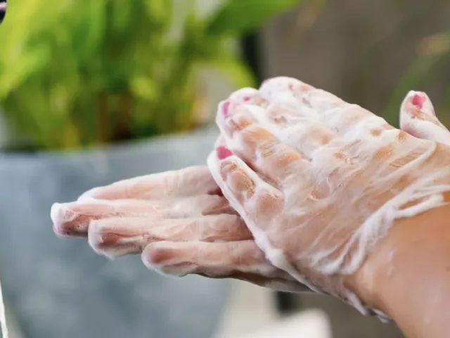 Woman washing her hands with soap